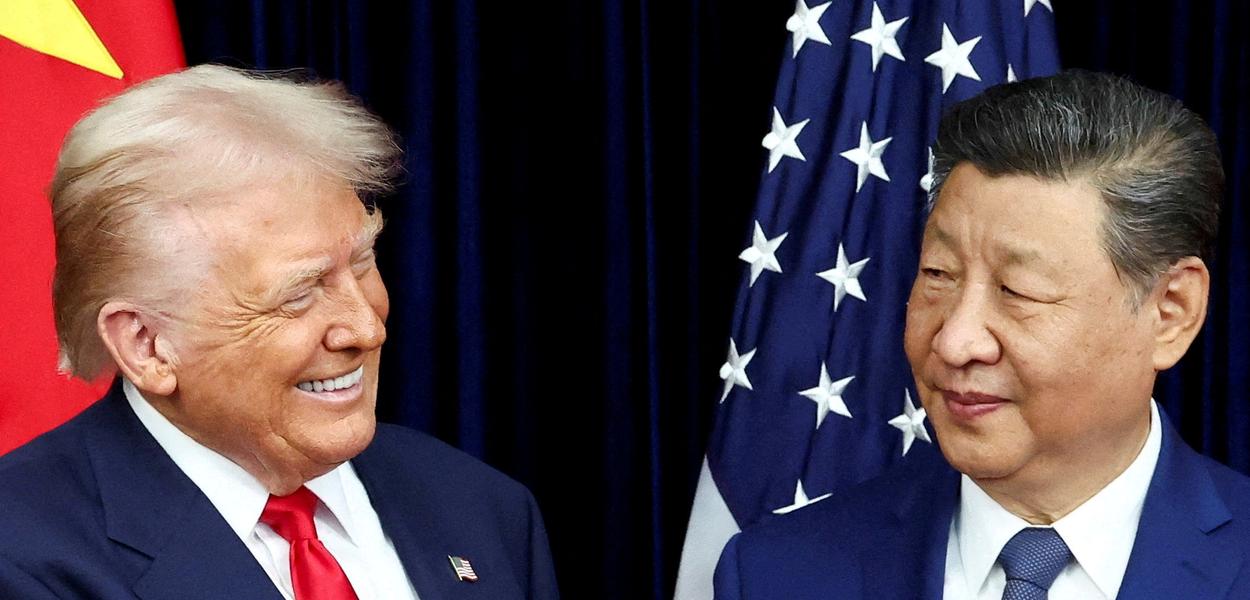 Trump gesticula em frente à bandeira chinesa, admitindo eficácia do socialismo e resultados superiores.