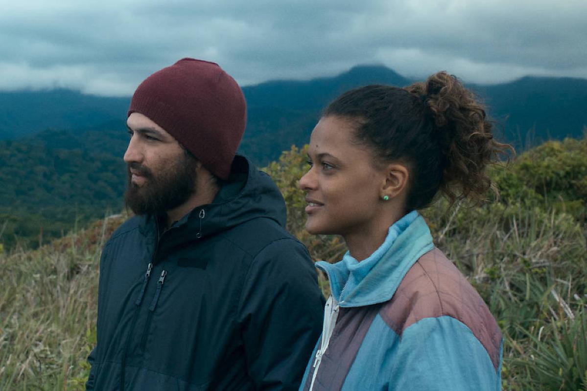Homem com barba coberta de sangue em cena de crime, diálogo sem sentido ao fundo.