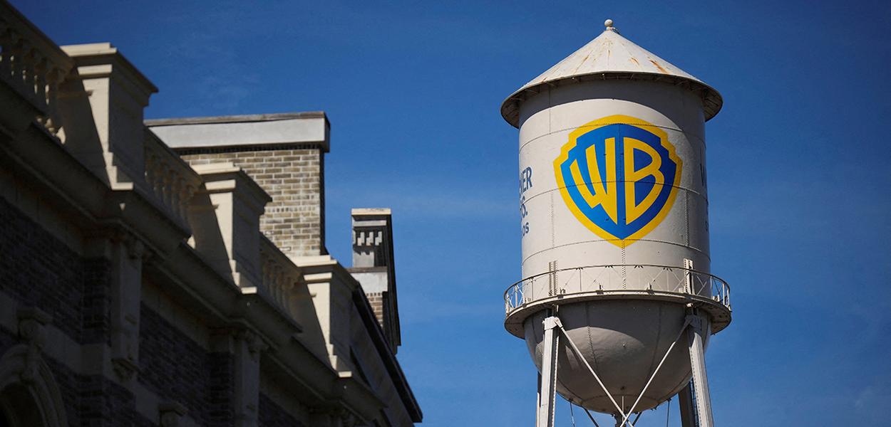 Estrelas de cinema se reúnem em torno de jornalistas, discutindo acordo entre Paramount e Warner.