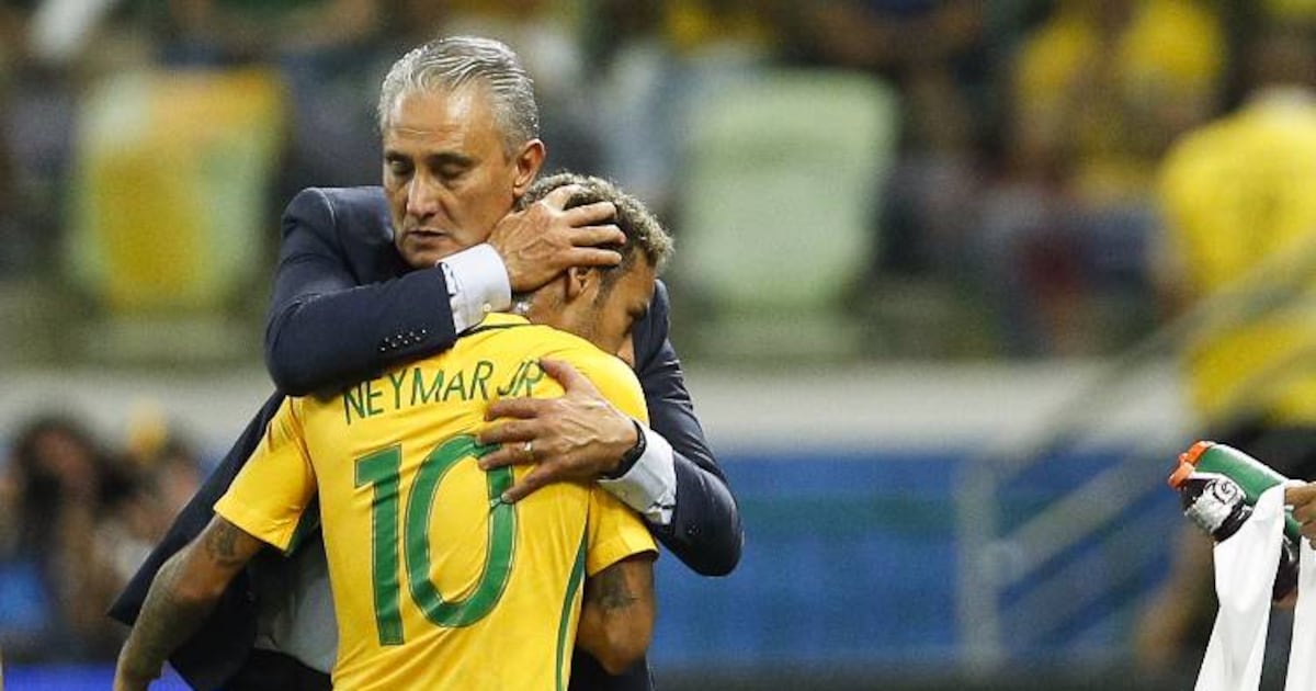 Técnico Tite, com expressão de desespero, sentado em frente a uma mesa com documentos de seleção.