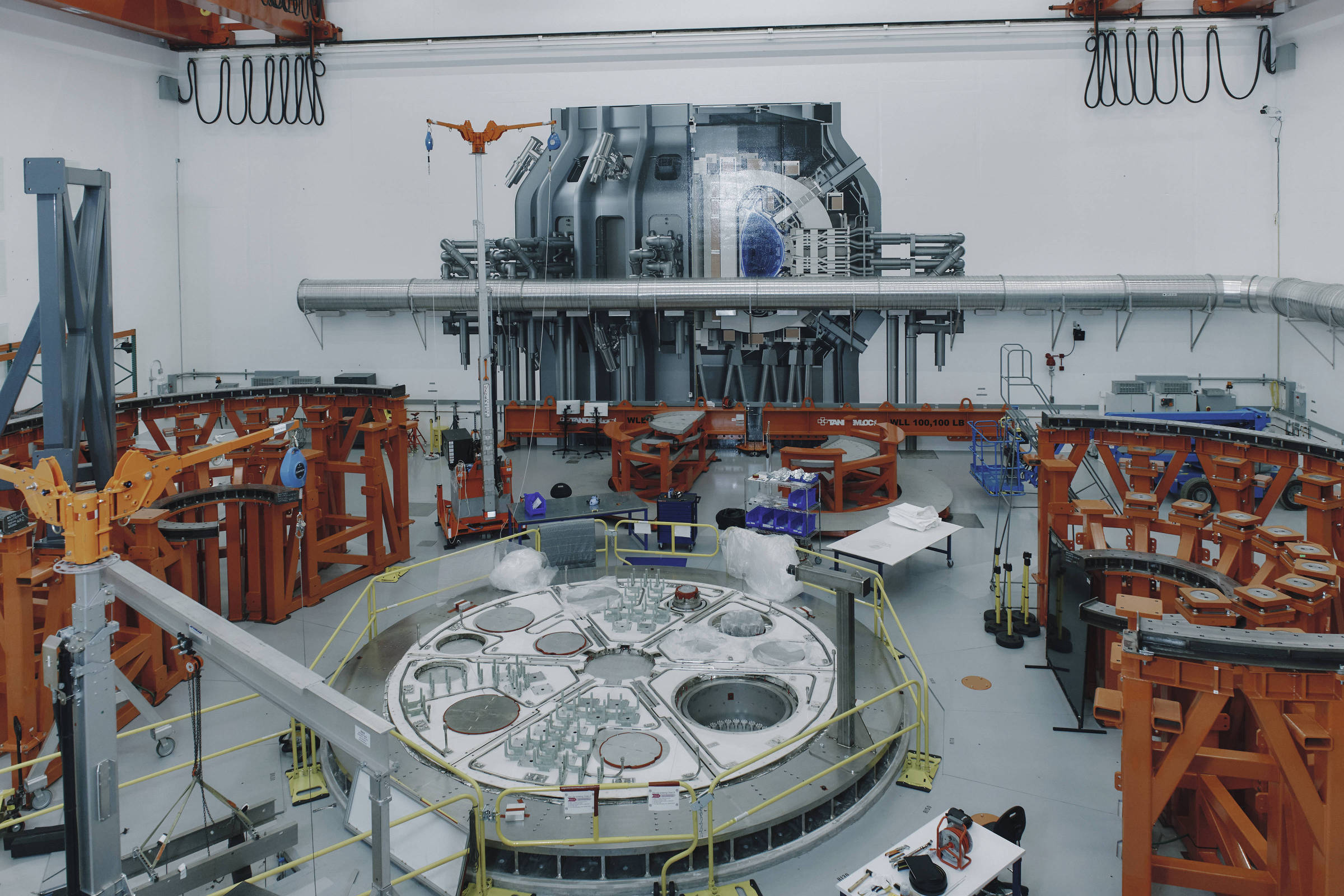 Cientistas trabalham em laboratório com equipamentos de fusão nuclear.