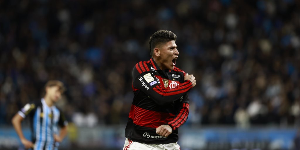 Equipe do Grêmio desolada após derrota para o Flamengo em campo de futebol.