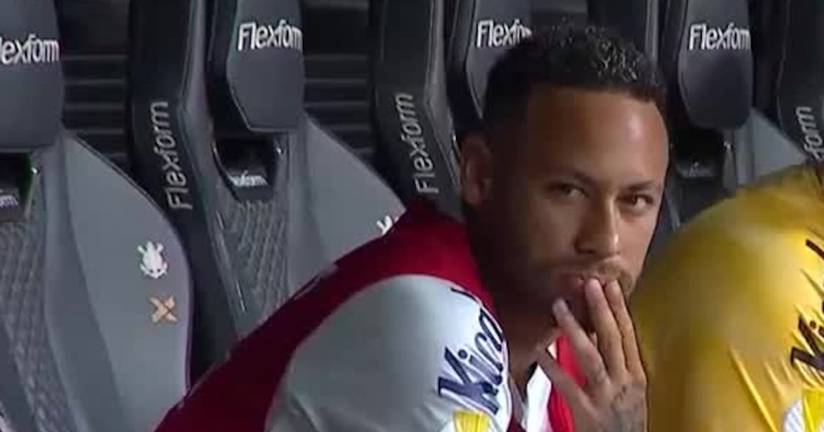 Jogador de futebol Neymar sentado no banco de reservas.