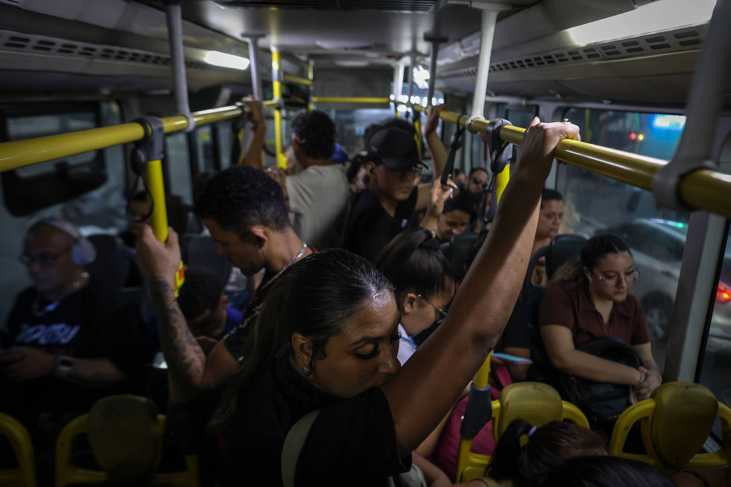 Mulher sorridente embarca em ônibus com bilhete zero, olhando para a câmera com expressão de surpresa.
