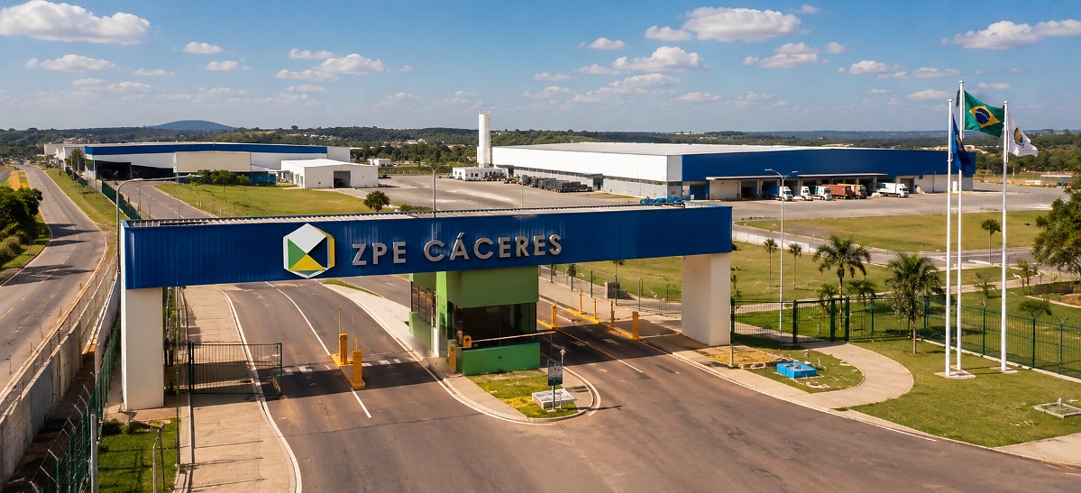 Cena de campo de cultivo no Oeste de Mato Grosso, mostrando maquinário agrícola e infraestrutura industrial.