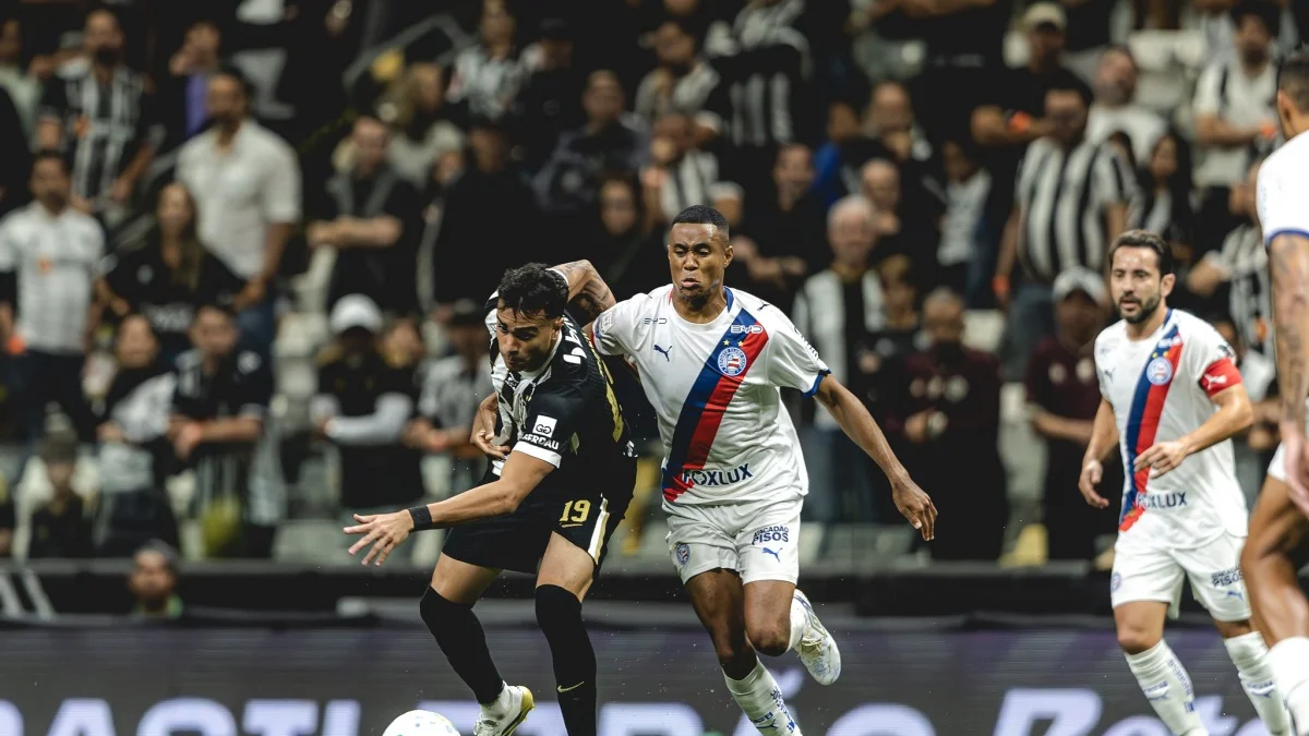 Equipe de futebol em ação, jogadores correndo no campo de futebol.