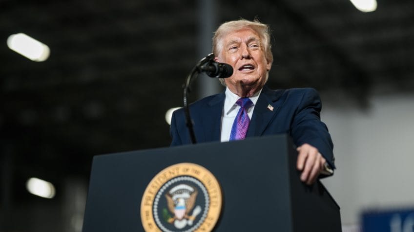 Trump anuncia possível ação militar dos EUA em Cuba em evento com bandeiras e público.