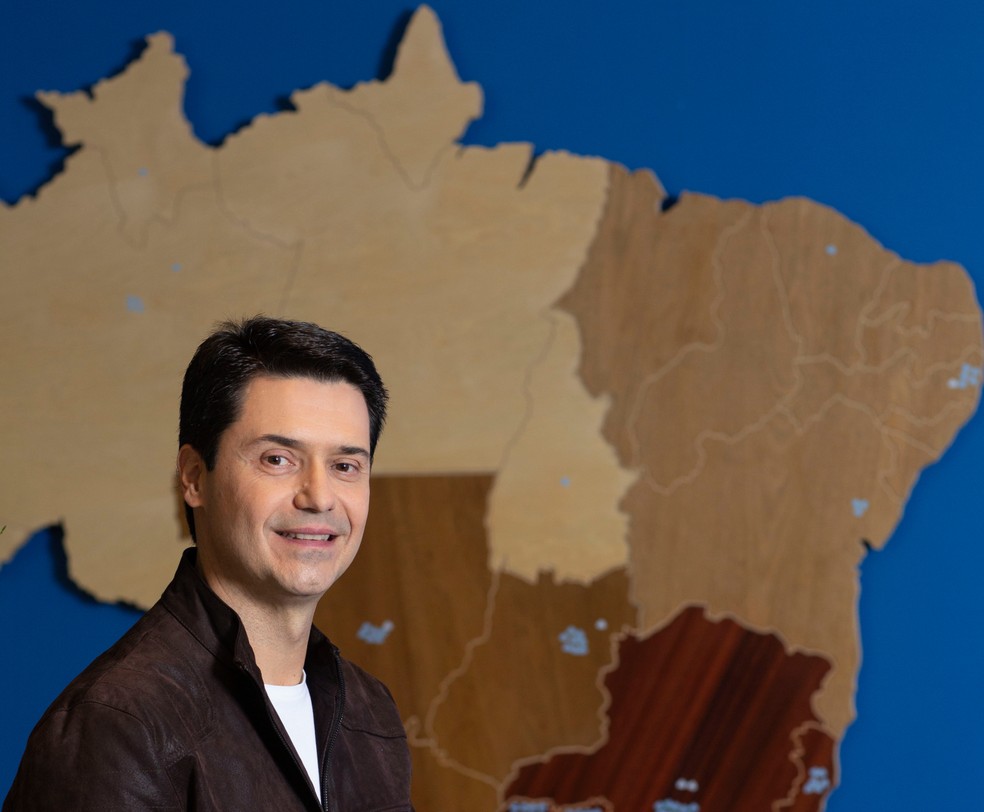 Empregado sentado à mesa, olhando para documentos de reforma tributária.