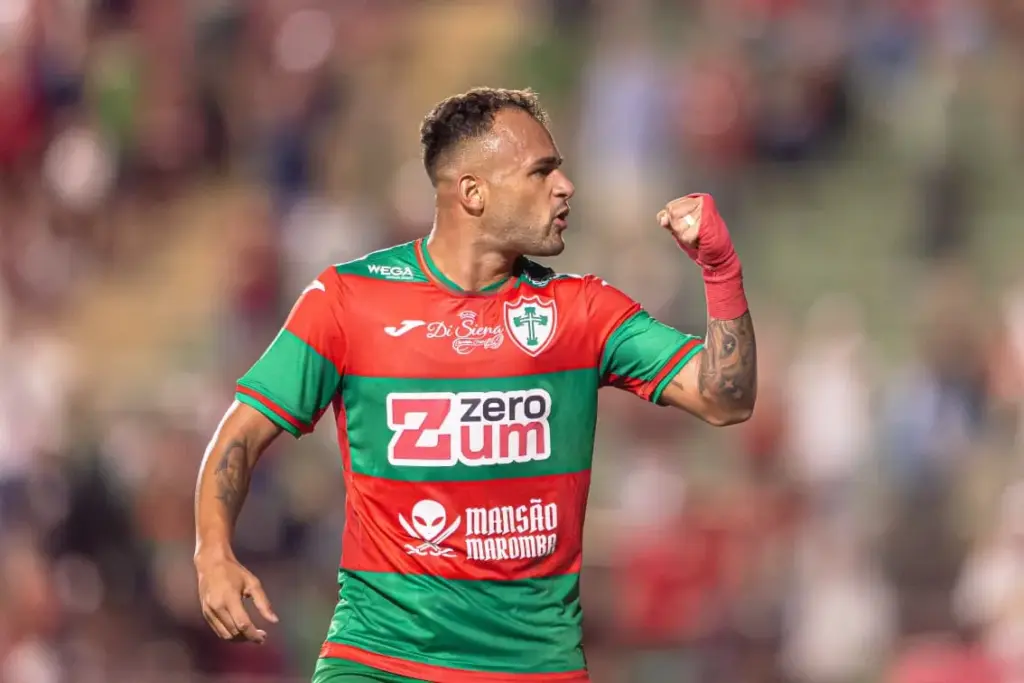 Time de futebol em campo, com jogadores celebrando vitória, em estádio lotado.