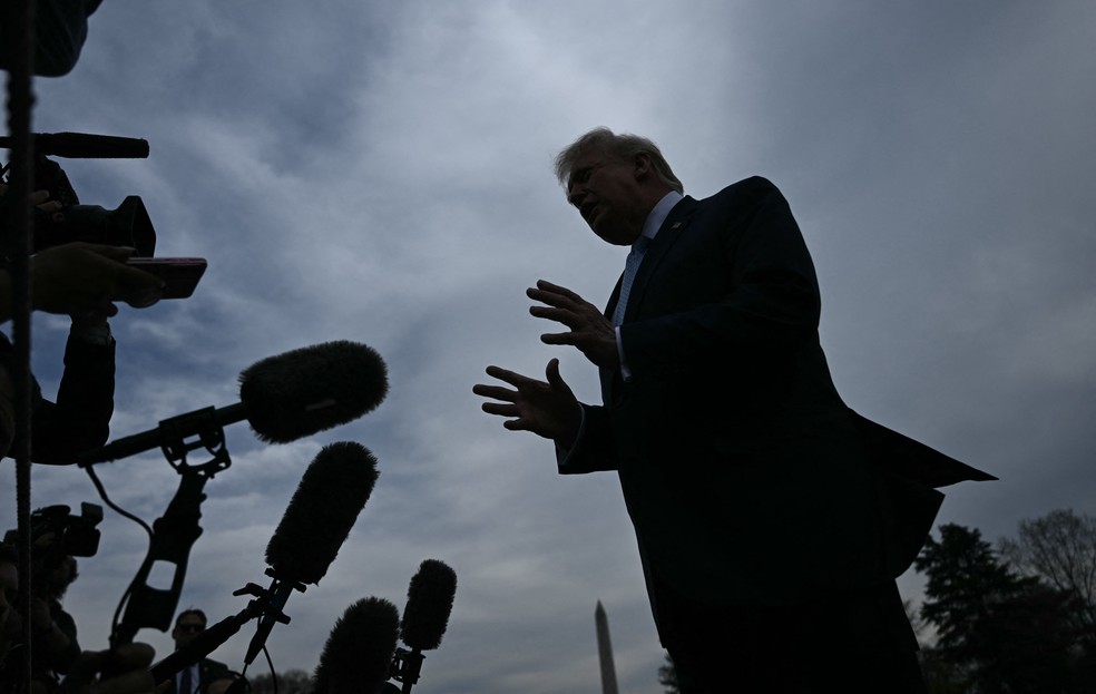 Imagem de jornalista analisando declarações de Trump em uma conferência de imprensa.