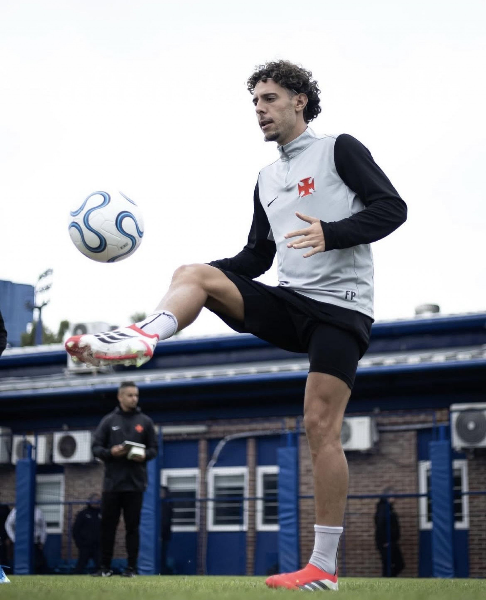 Nuno Moreira em ação no campo de futebol, com Renato ao lado, expressão de concentração no rosto.