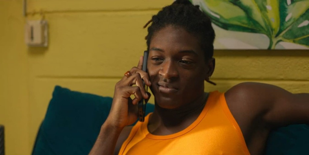 Jornalista sentado à mesa com computador e papel, lendo notícias sobre a segunda temporada de Bandi na Netflix.