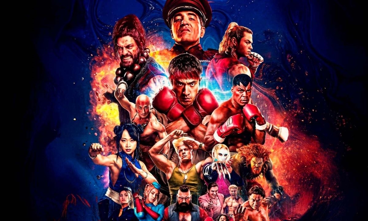 Jornalista segura uma cópia do filme Street Fighter enquanto olha para o primeiro trailer em uma tela de computador.