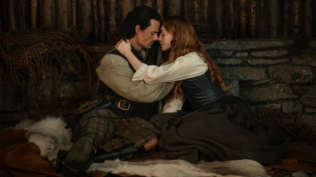 Jornalista segurando um jornal com manchete sobre Outlander: Blood of My Blood.