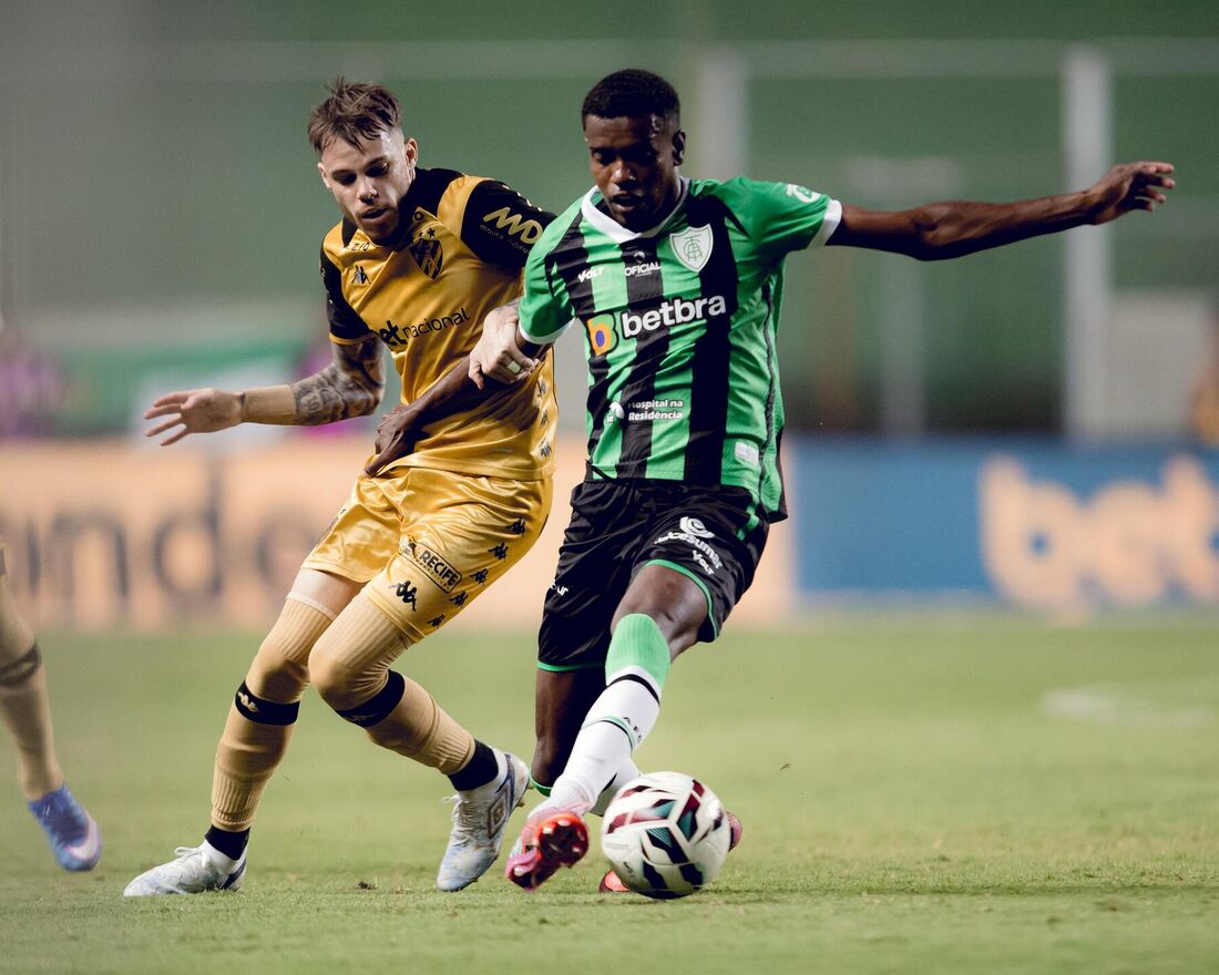 Jogo de futebol entre Sport e América-MG em campo de grama verdejante.