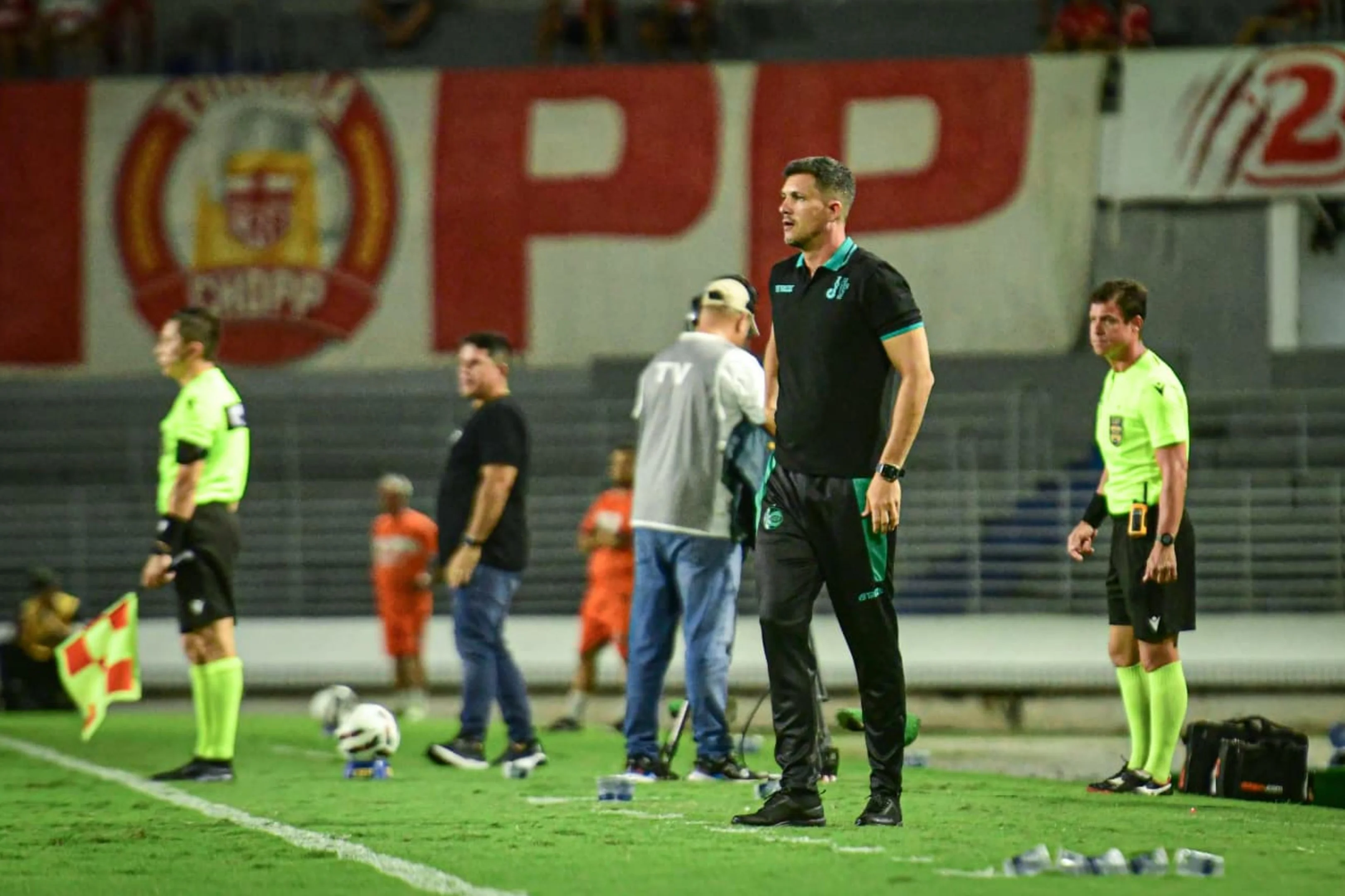 Técnico da Juventude sorri ao lado do time após vitória importante.