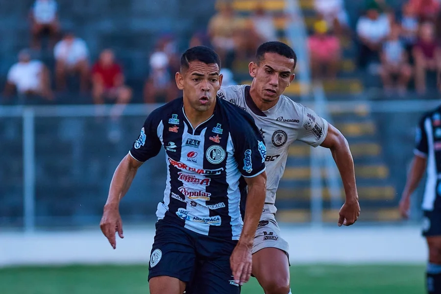 Jogadores de futebol em ação em estádio lotado.