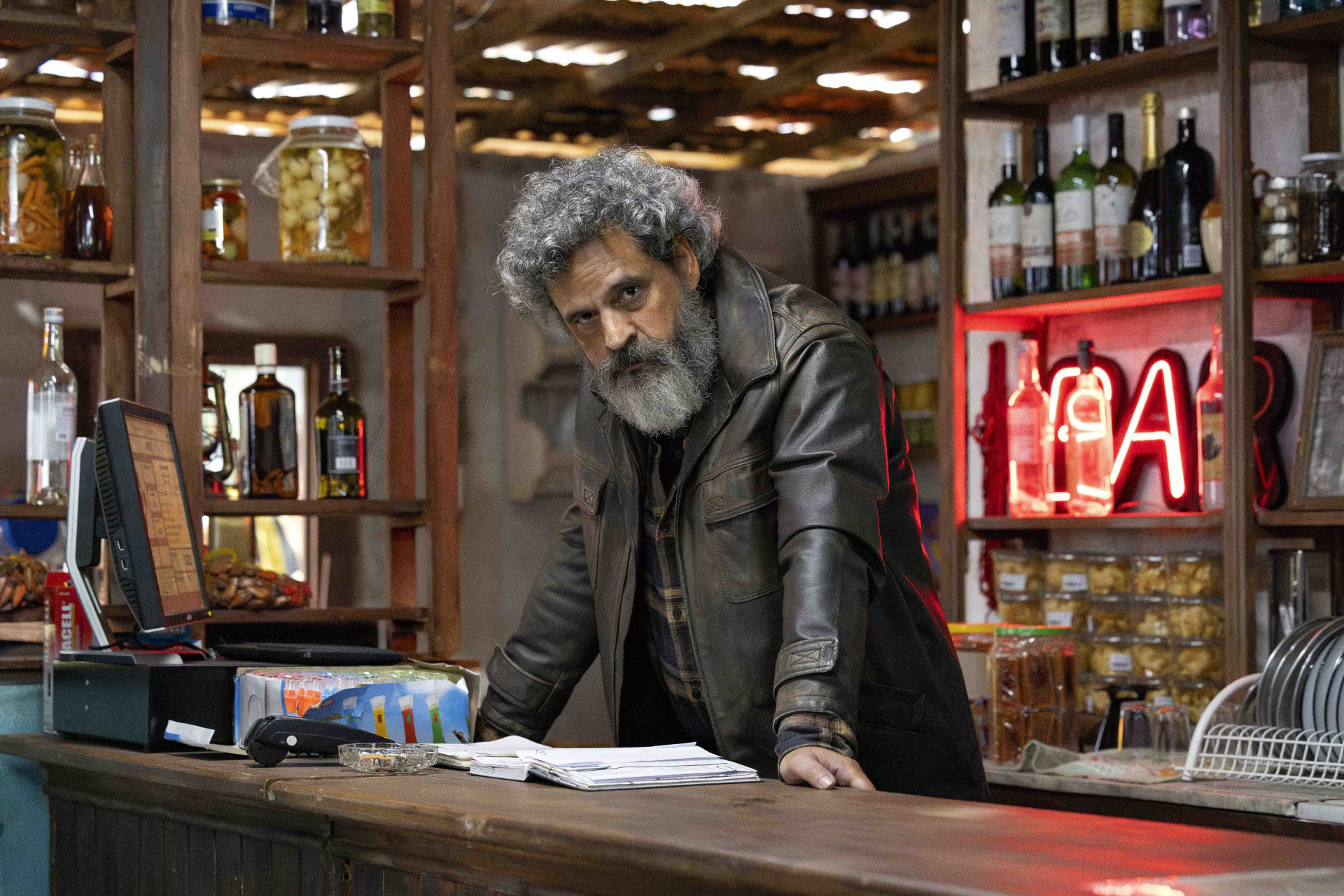 Ator e equipe da série "Os Outros" em cenário de notícia jornalística.