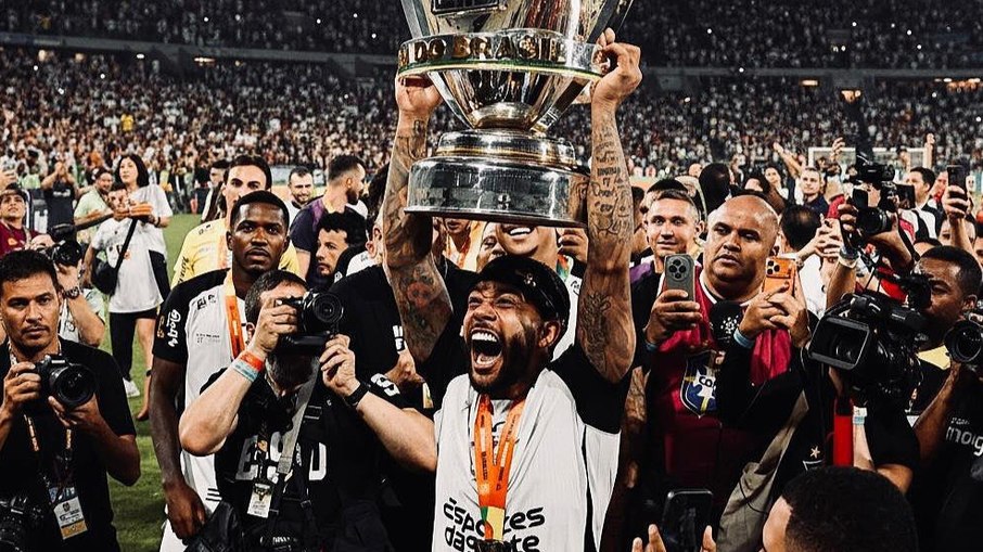 Jogadores de futebol se preparando para partida em estádio lotado.