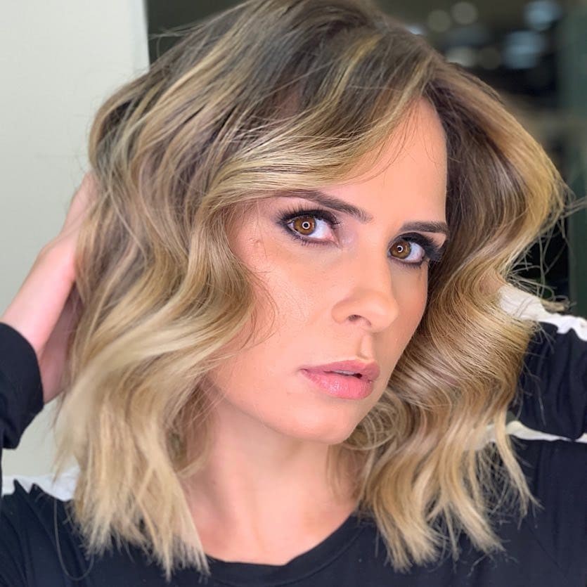 Ana Paula Renault apresenta notícia jornalística em estúdio, com fundo de tela e gráficos.