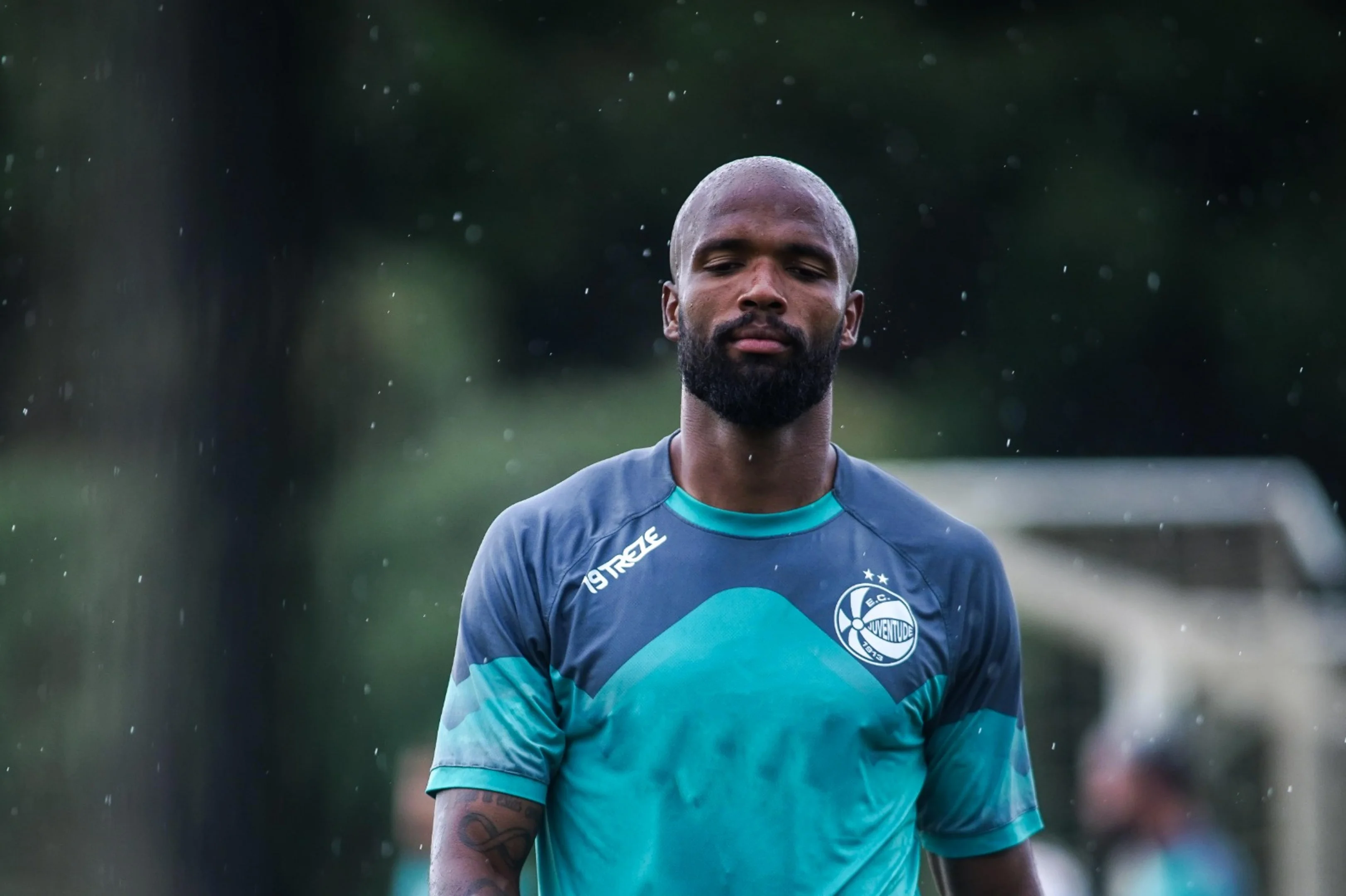 Zagueiro do Juventude sorri ao lado de sua equipe após vitória, aliviado da pressão.