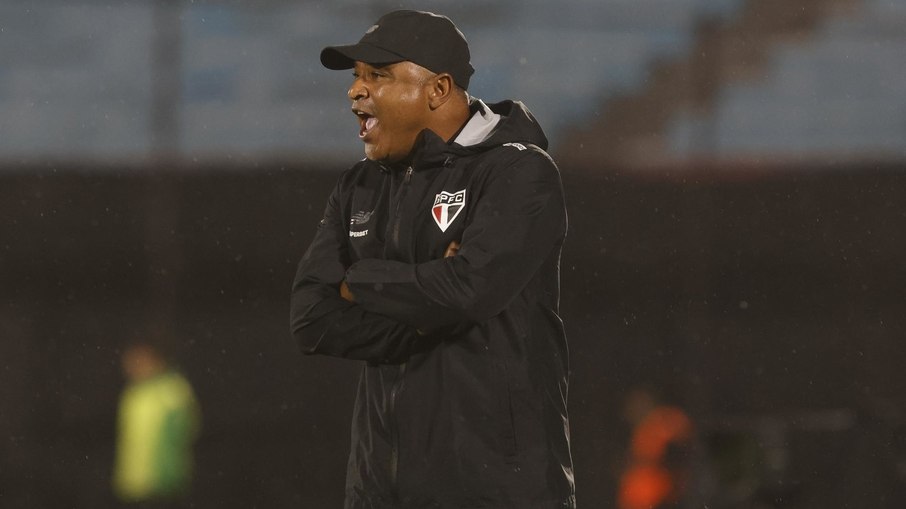 Roger Machado é demitido do São Paulo, com olhar sombrio e equipe técnica ao redor.