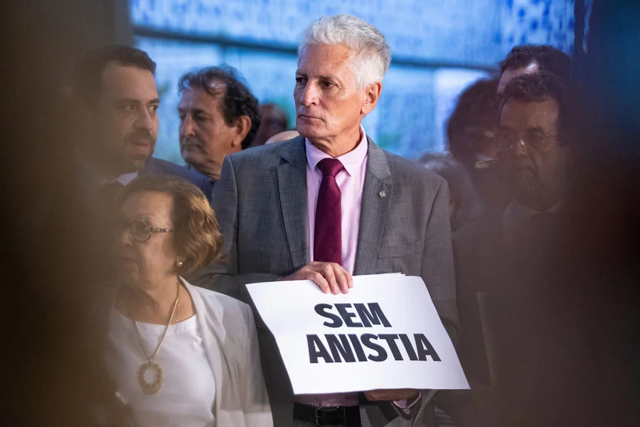 Petista em audiência no STF, cercado por advogados e seguranças, enquanto acusa Flávio de tentar silenciar a oposição.