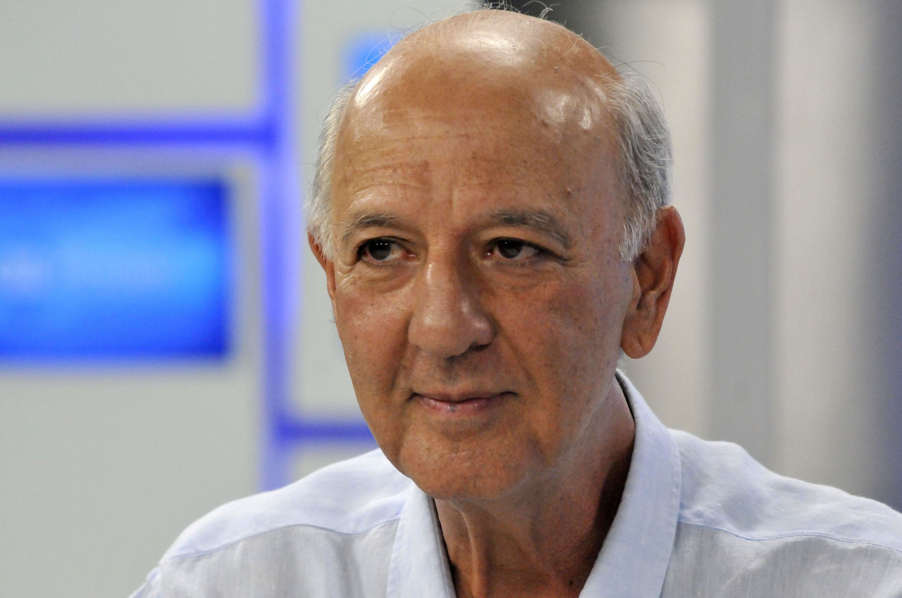Políticos se reúnem em torno de uma mesa de xadrez, com peças em movimento.