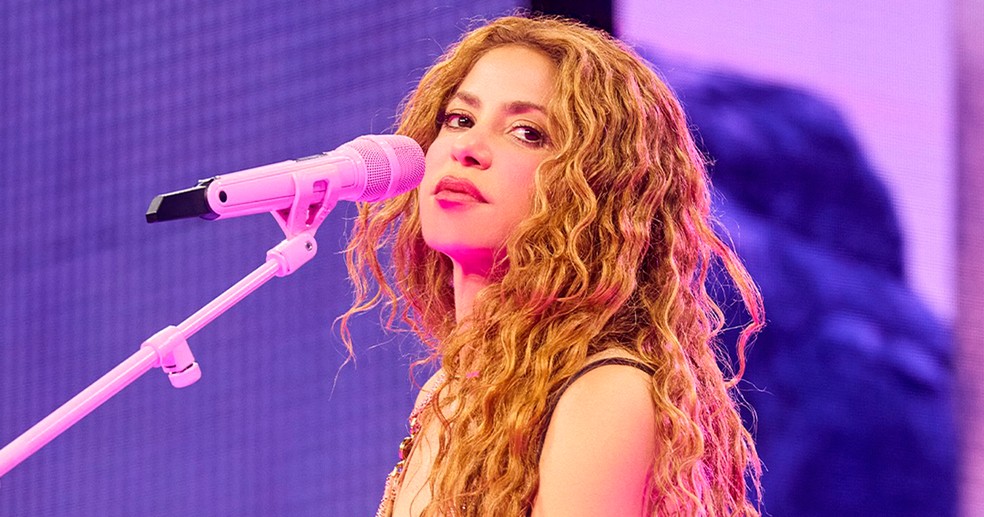 Shakira sorri ao falar sobre Piqué em entrevista jornalística.
