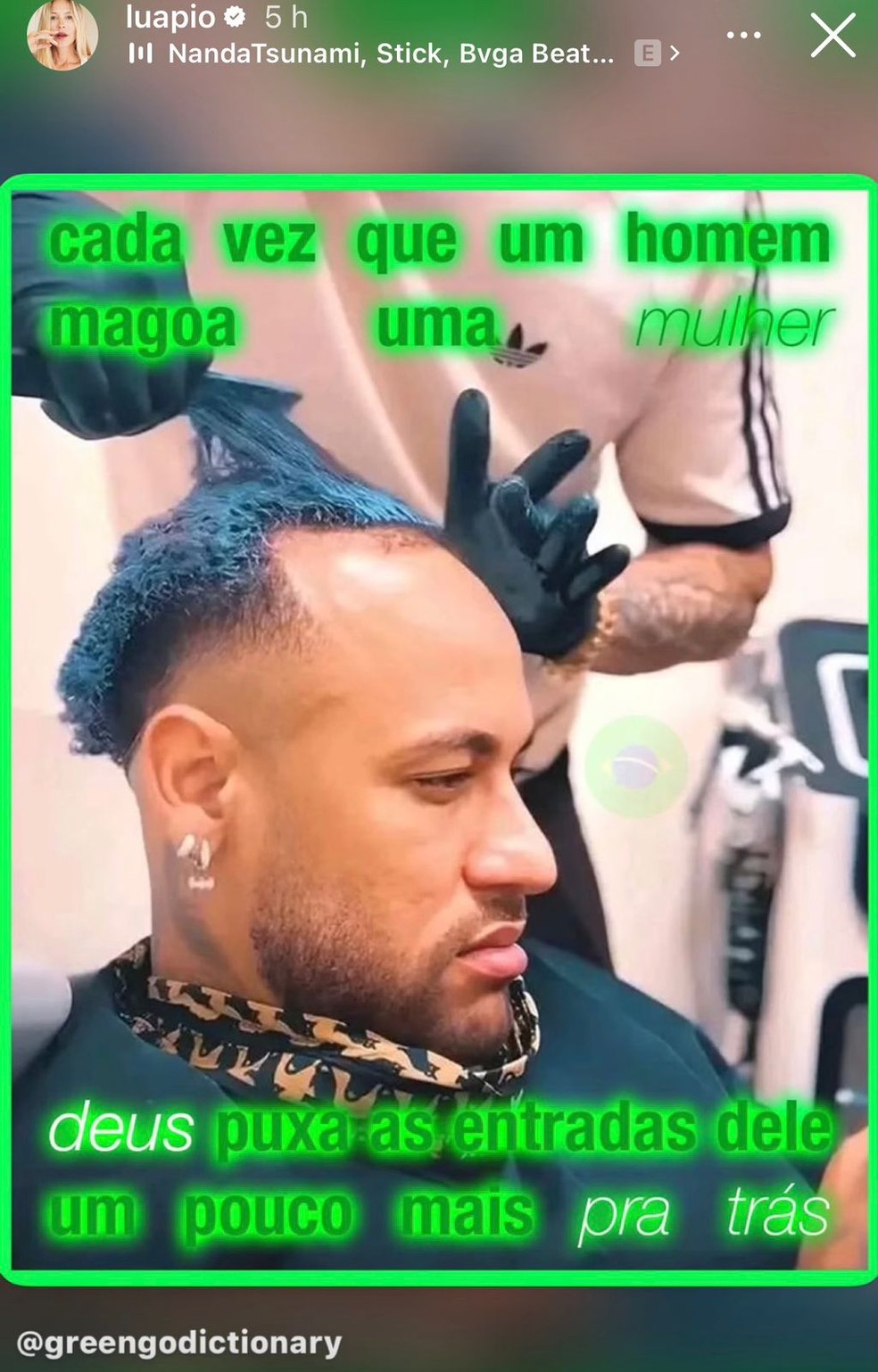 Luana Piovani sorri enquanto segura um cartaz com uma mensagem sarcástica sobre a lesão de Neymar.