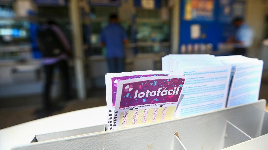 Cinco pessoas recebem cheques de R$ 723 mil cada, com sorrisos de alegria e comemoração.