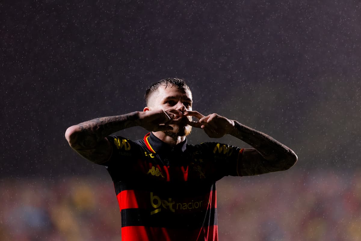 Jornalista escrevendo sobre futebol em uma sala de imprensa.