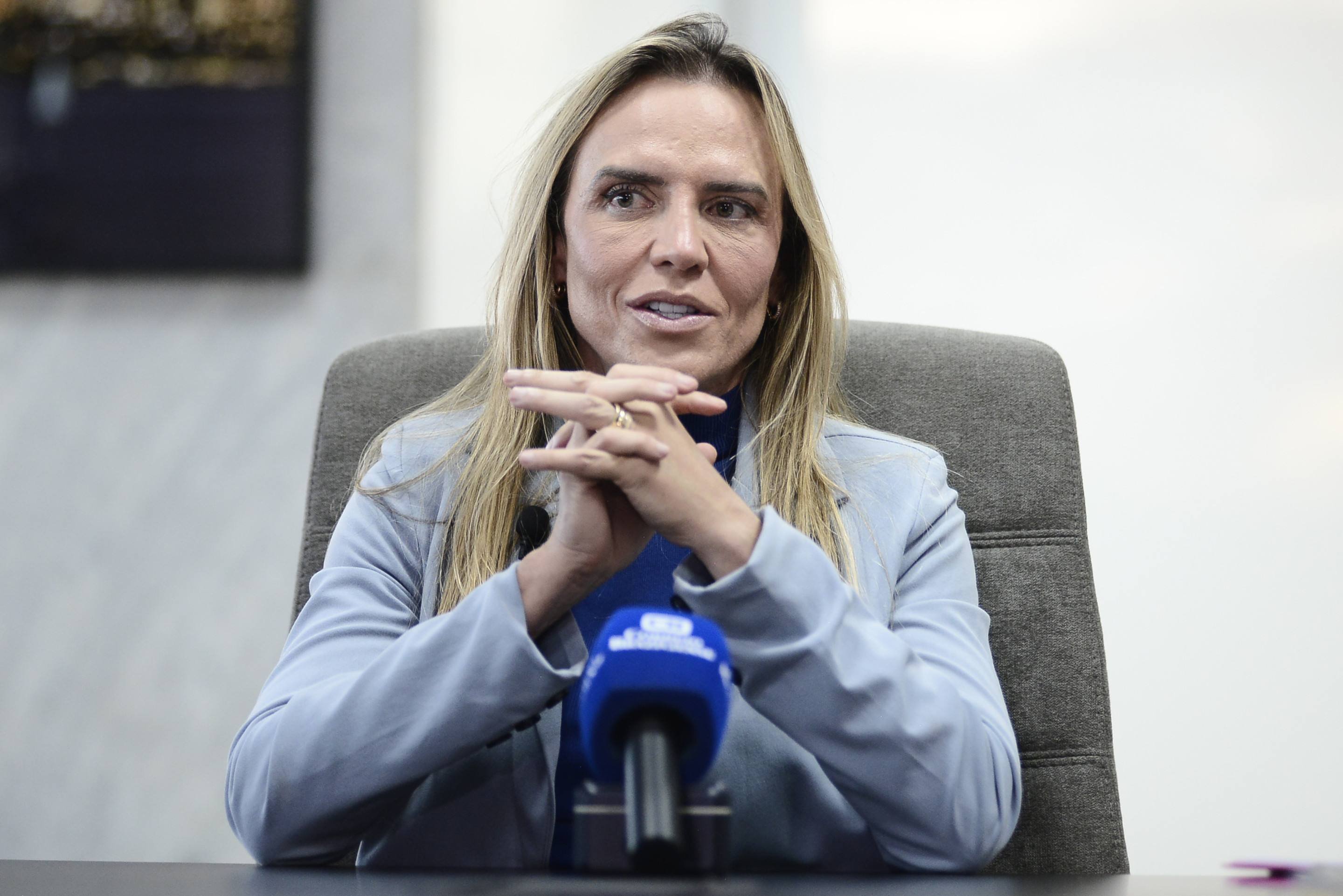 Mulheres em uniforme de resgate aéreo em aeroporto, com equipamentos e olhares determinados.