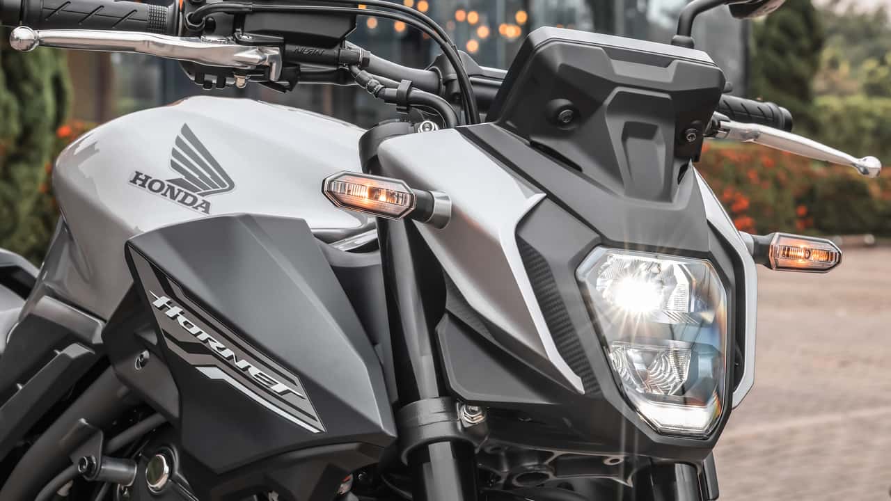 Motorista segura a chave da Honda CB500 Hornet 2027 em uma loja de motos.