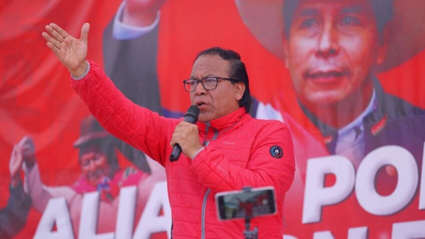 Imagem de um jornalista segurando um jornal com manchete sobre processo contra Sánchez no Peru.