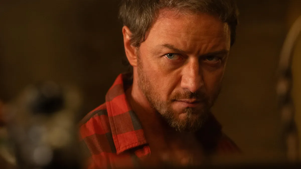 Jornalista segurando três cartazes de filmes de suspense da Netflix