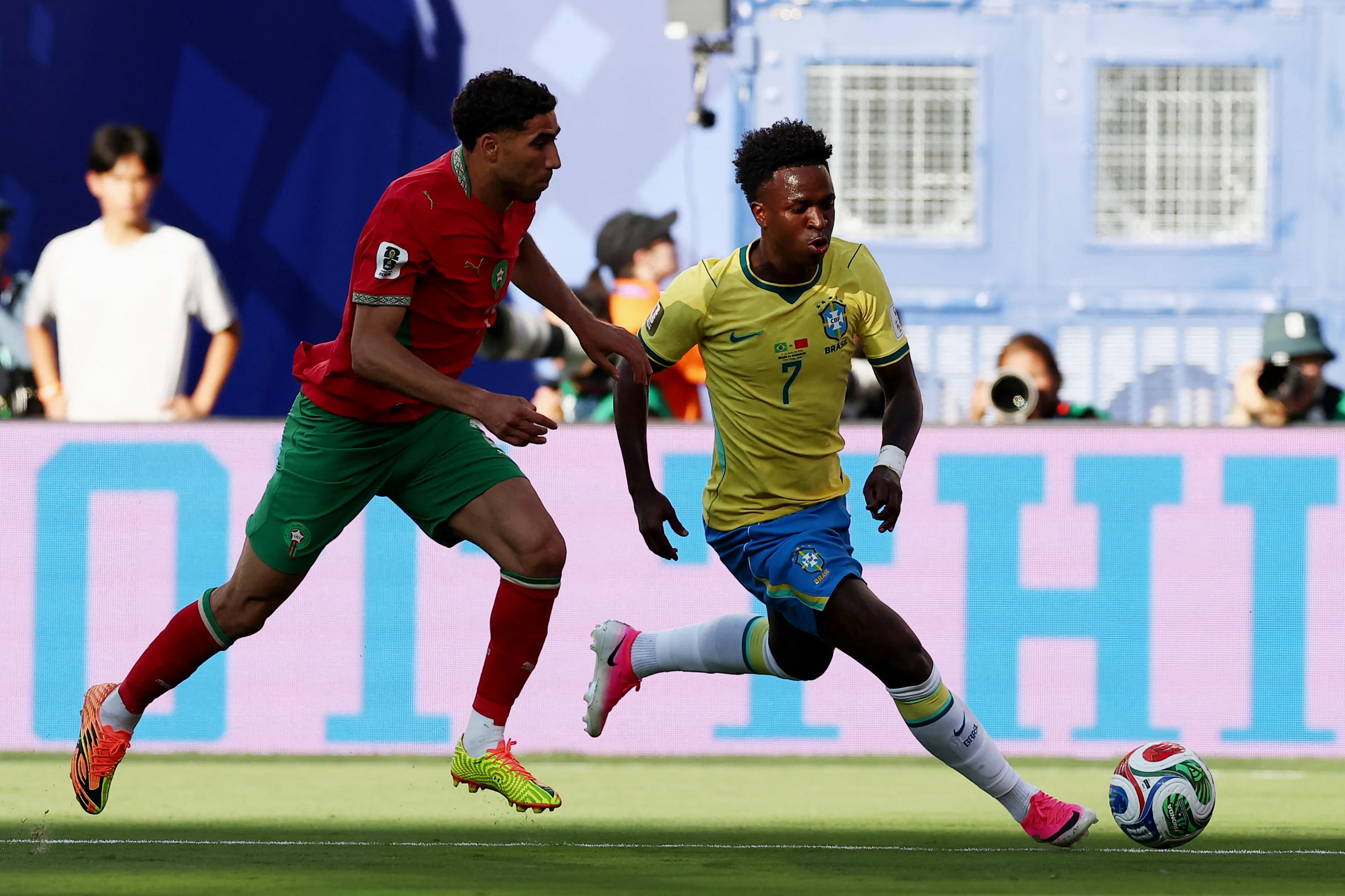 Jogadores de futebol jovens em campo, com uniforme da equipe, durante jogo de Série B.