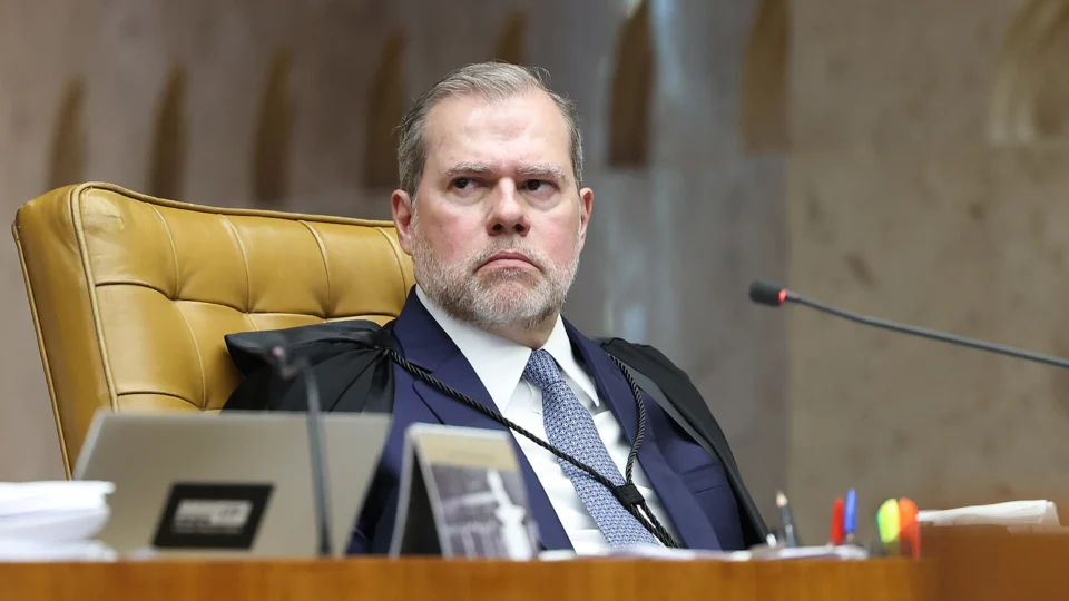 Homem de negócios Durigan em frente a uma mesa de negociação, com um mapa de economia em segundo plano.