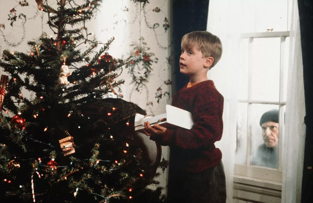 Notícia de jornal com Macaulay Culkin em primeiro plano, lendo um artigo sobre um possível novo filme de "Esqueceram de Mim".